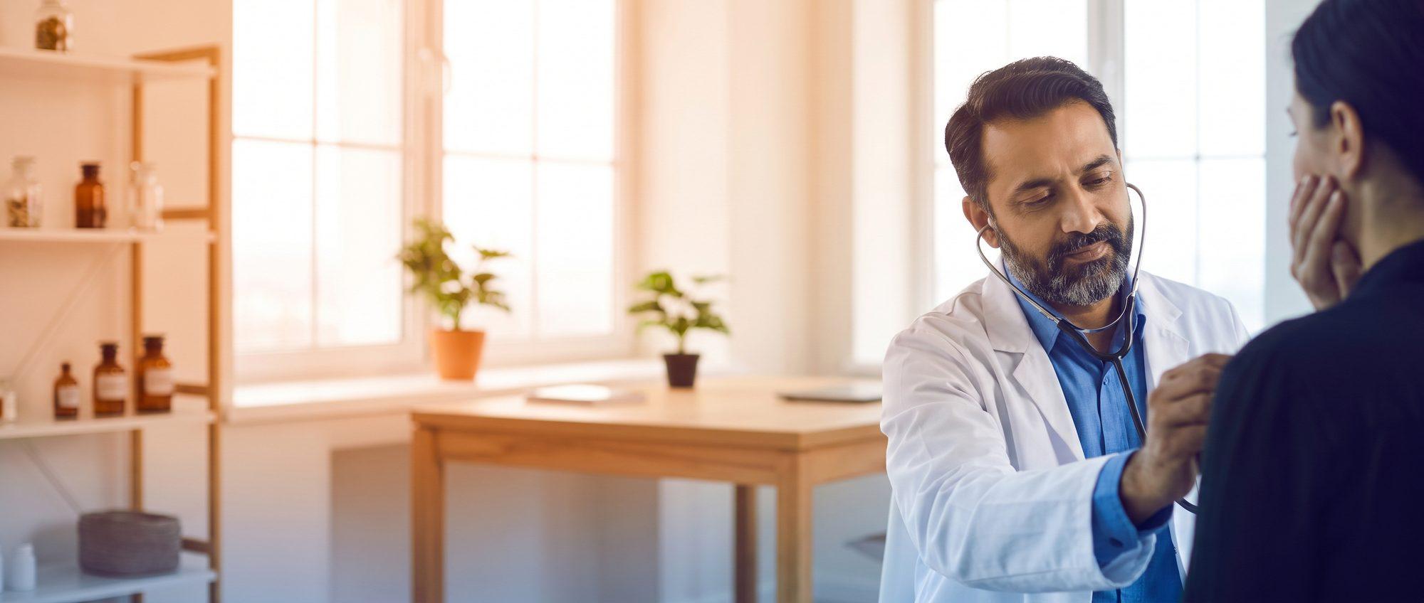 Homeopathy doctor listening to a patient’s breathing with a stethoscope